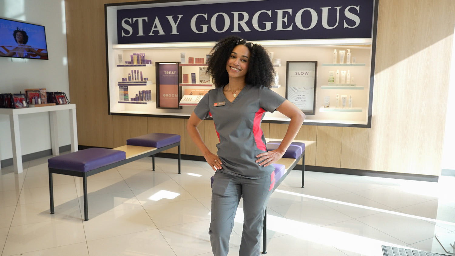 A smiling EWC wax specialist at the front area of a wax center location.