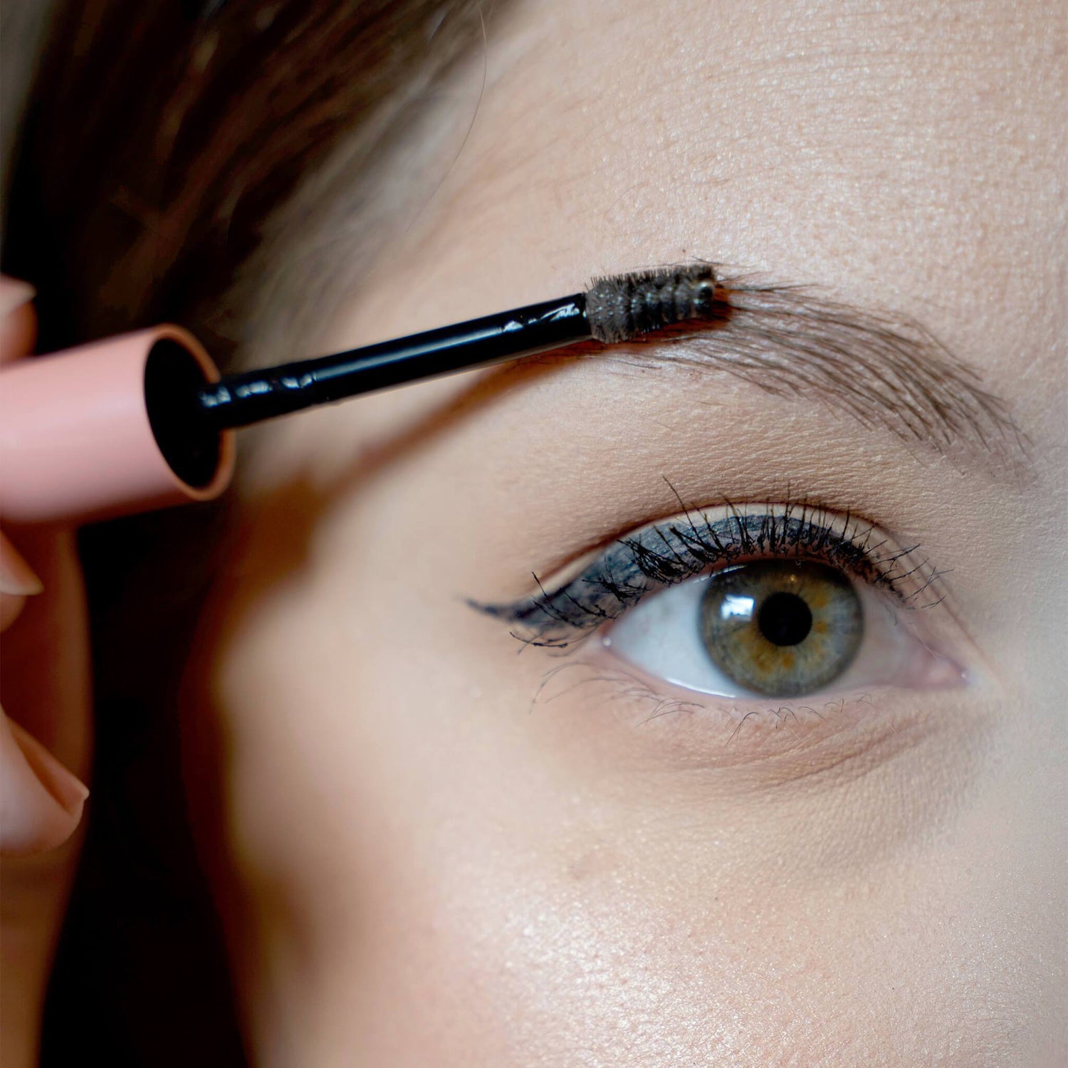 Woman applying EWC GROOM Clear Brow Gel to her eyebrow
