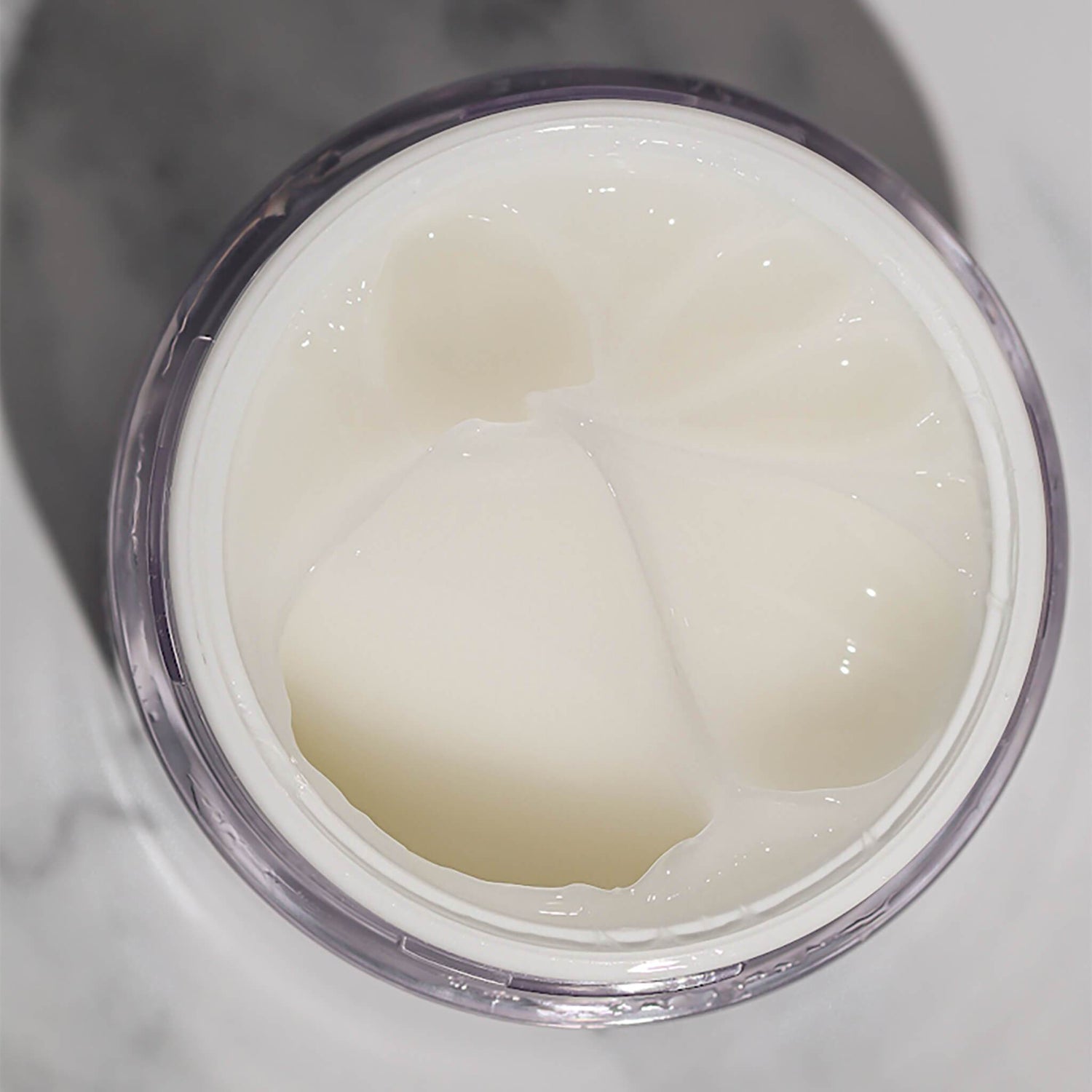 Top view of an open container of EWC TREAT Face & Body Exfoliating Gel.
