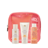 4 Piece Summer Oasis Travel Kit, EWC SLOW travel size products (body wash, body polish and shimmer body oil) arranged in front of a coral pouch.
